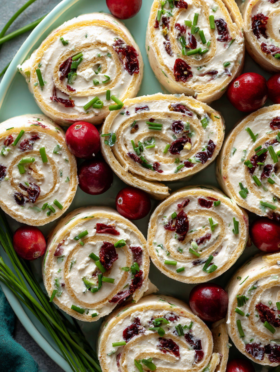 Eine Platte mit verschiedenen Sandwiches, die mit Zwiebeln und Roten Beeren garniert sind.