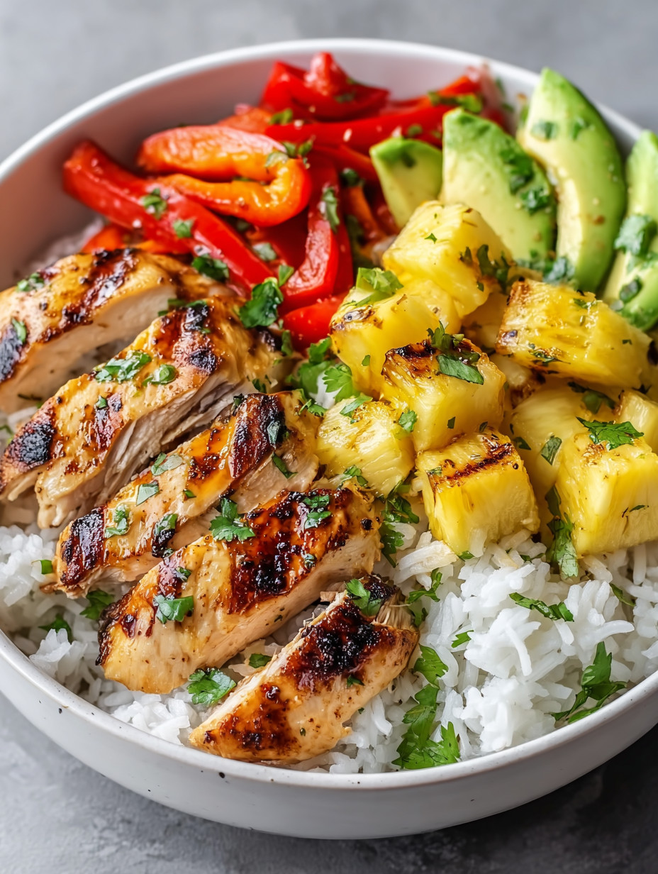 Ein weißer Teller mit einer Mischung aus Rice, Pineapple, Avocado, Paprika, Zwiebeln und Chicken.