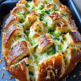 Ein Baguette mit Käse und Knoblauch, der in Streifen zerlegt wurde.